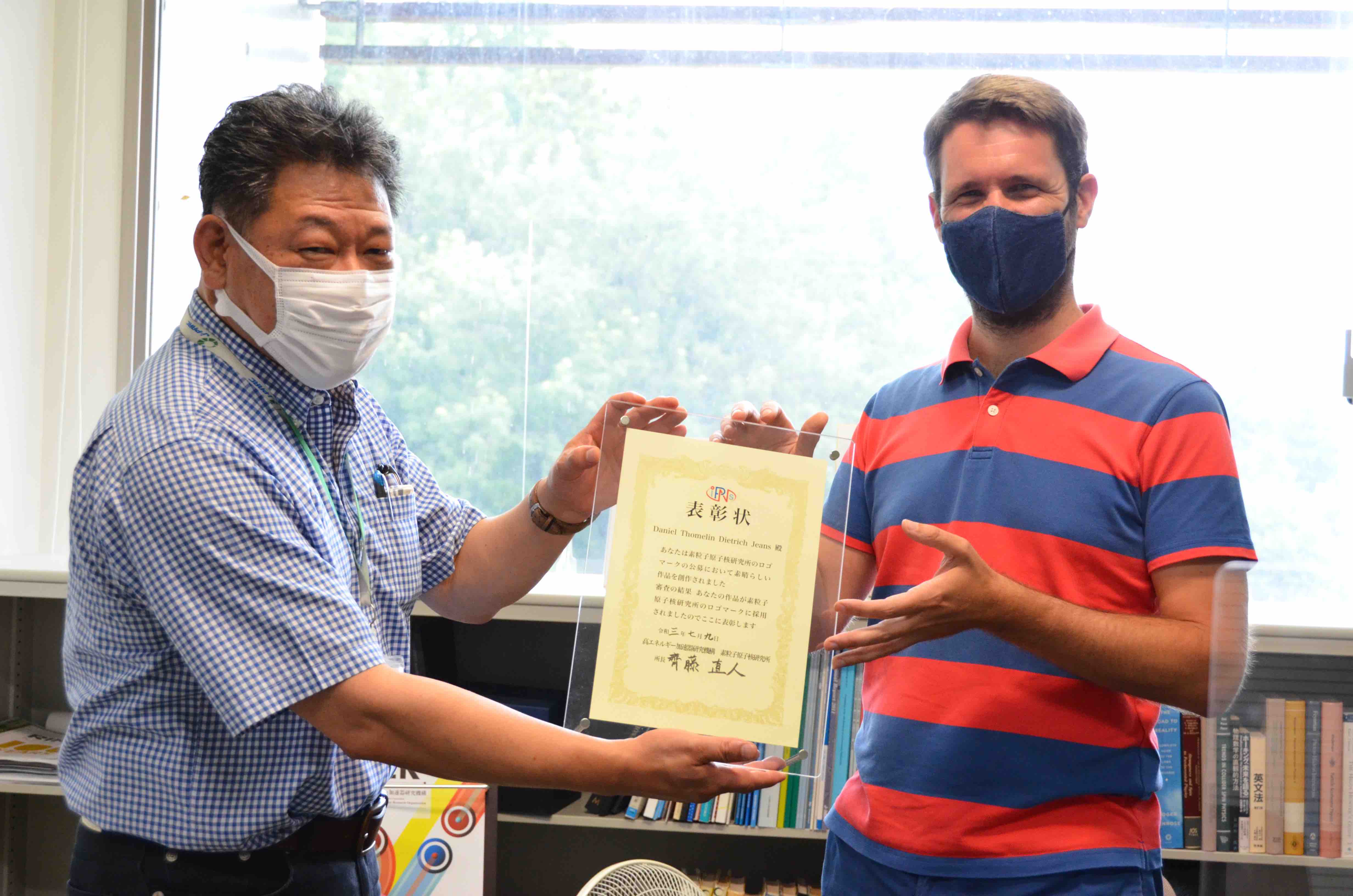 齊藤直人 所長（写真左）から記念の賞状を手渡されるDaniel Jeans准教授（写真右）。