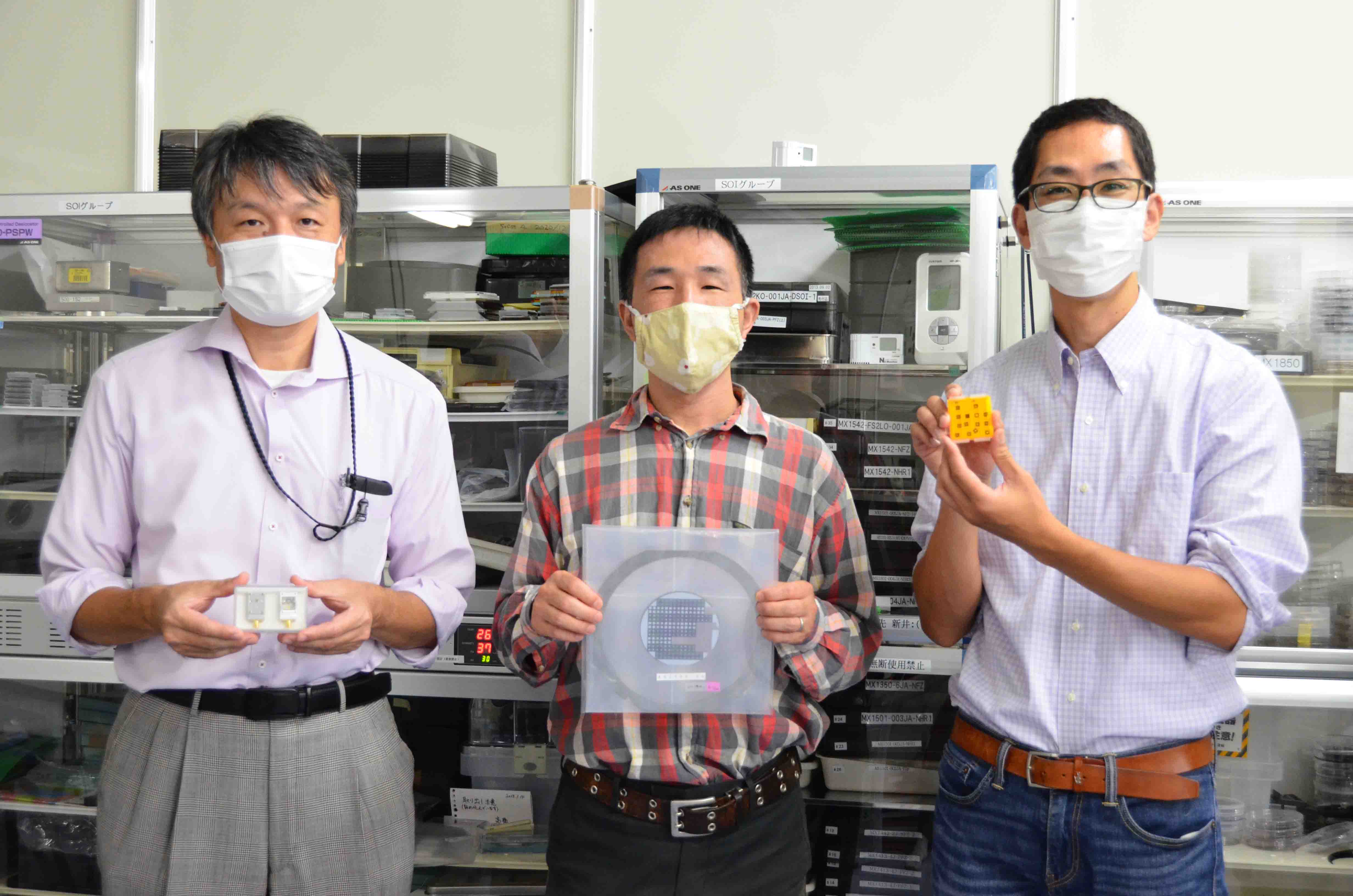 開発中のシリコンカーバイド素粒子センサーを手にする藤田陽一 専門技師、深尾祥紀 助教、岸下徹一 准教授(左から)。